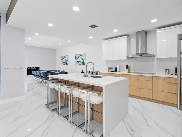 kitchen featuring light countertops, wall chimney range hood, modern cabinets, and white cabinetry