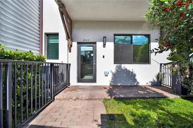 doorway to property featuring stucco siding