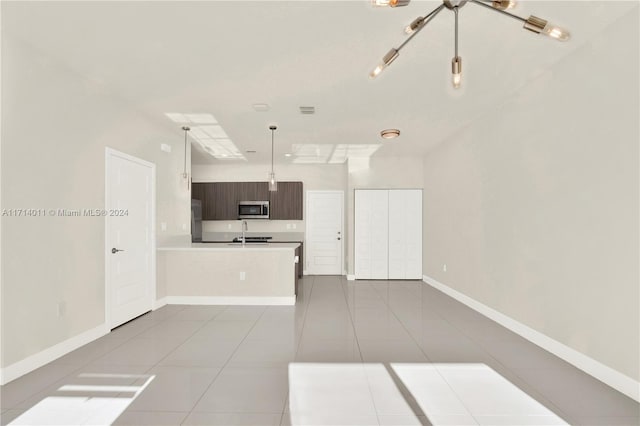 kitchen with sink, hanging light fixtures, dark brown cabinetry, light tile patterned floors, and kitchen peninsula