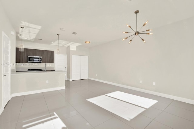 unfurnished living room featuring light tile patterned flooring and an inviting chandelier