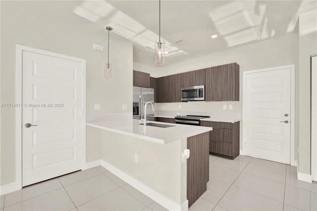 kitchen featuring sink, hanging light fixtures, stainless steel appliances, kitchen peninsula, and light tile patterned floors