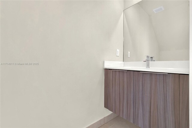 bathroom featuring tile patterned floors, vanity, and lofted ceiling