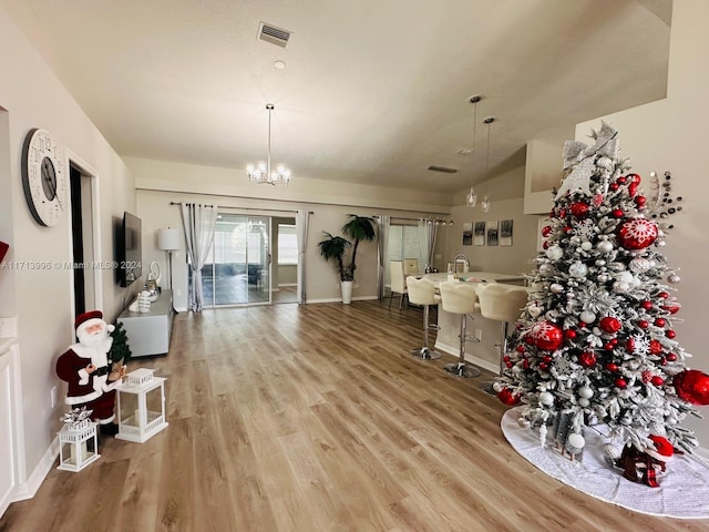 dining room featuring a chandelier, hardwood / wood-style flooring, and lofted ceiling