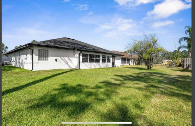 rear view of property featuring a yard