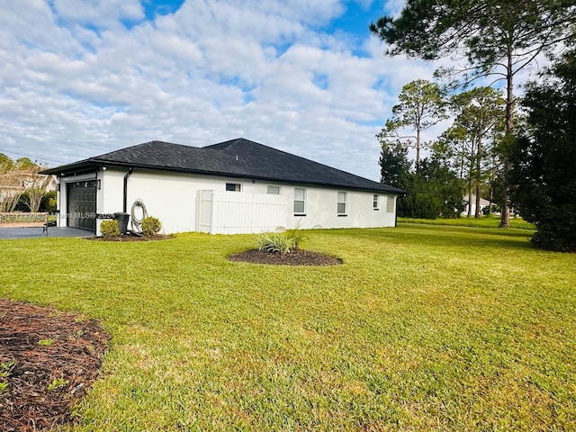 view of side of property featuring a yard and a garage