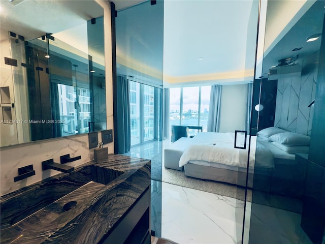 bathroom featuring a shower with door and vanity