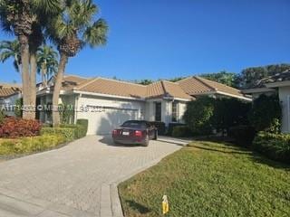 view of front of home with a garage and a front lawn