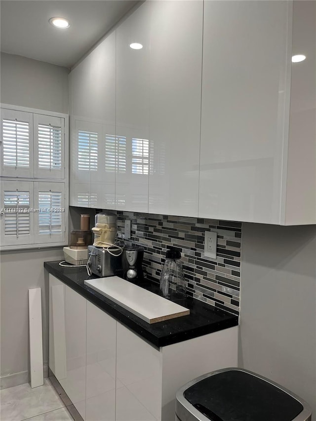 kitchen with backsplash, white cabinets, and light tile patterned flooring