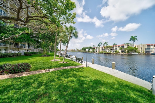 view of dock with a yard and a water view