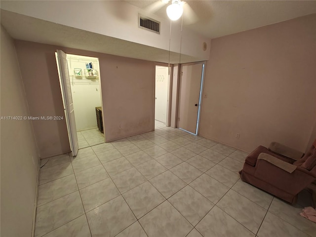 unfurnished room with light tile patterned floors and ceiling fan