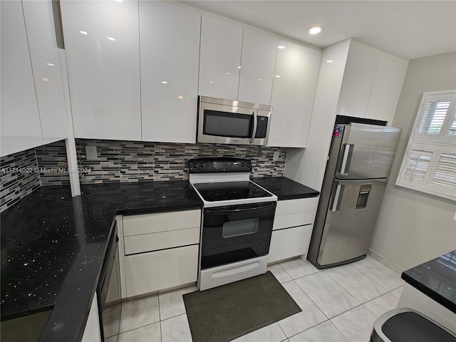 kitchen featuring white cabinets, appliances with stainless steel finishes, backsplash, and light tile patterned floors