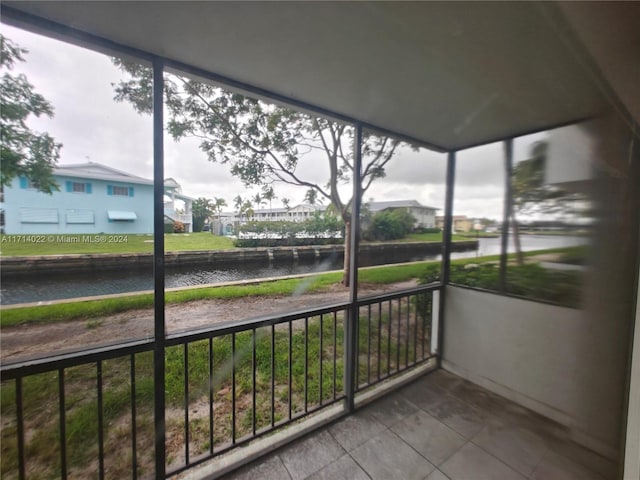 unfurnished sunroom featuring a water view