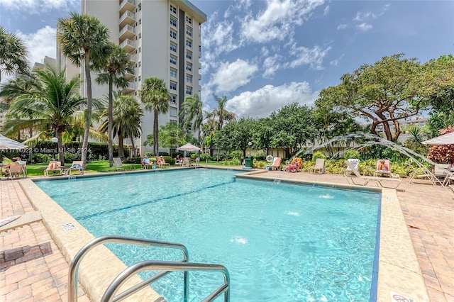 view of swimming pool with pool water feature and a patio area