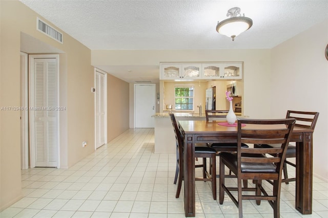 tiled dining room with a textured ceiling