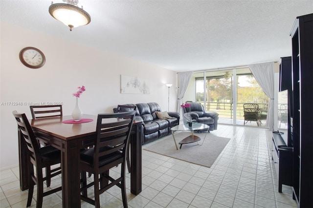 dining area with a textured ceiling and light tile patterned flooring