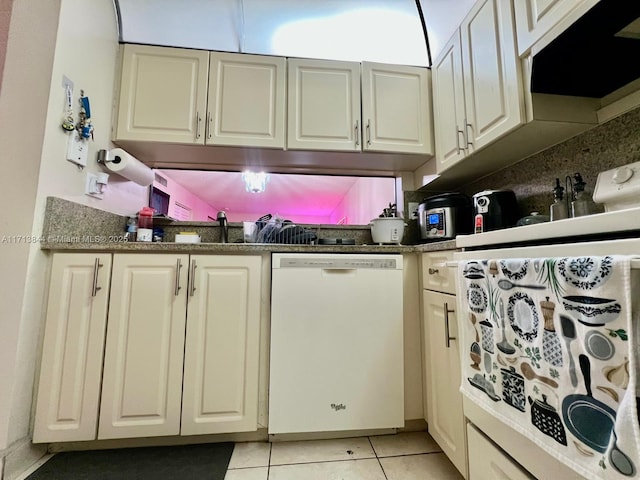 kitchen featuring dark countertops, light tile patterned flooring, white dishwasher, and white cabinets