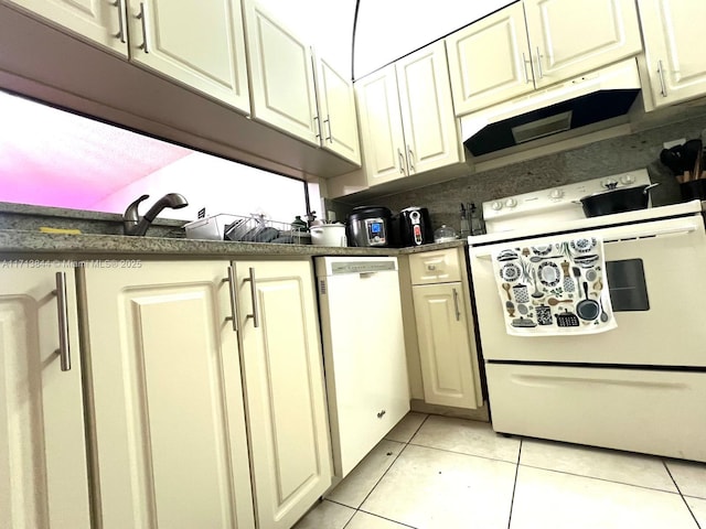 kitchen with white appliances, light tile patterned flooring, and dark countertops