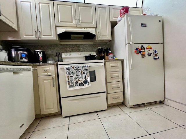 kitchen featuring white appliances, light tile patterned flooring, dark countertops, and under cabinet range hood