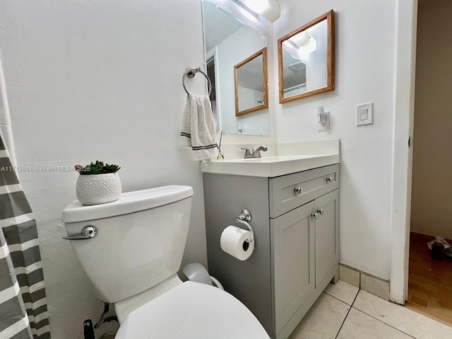 bathroom featuring tile patterned floors, toilet, and vanity