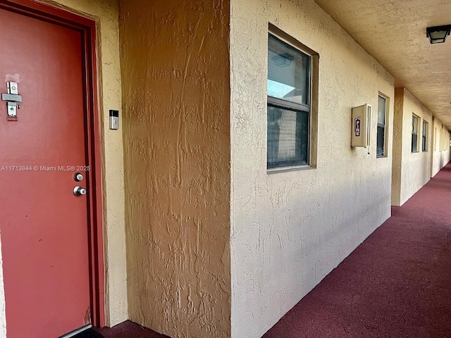 entrance to property featuring stucco siding