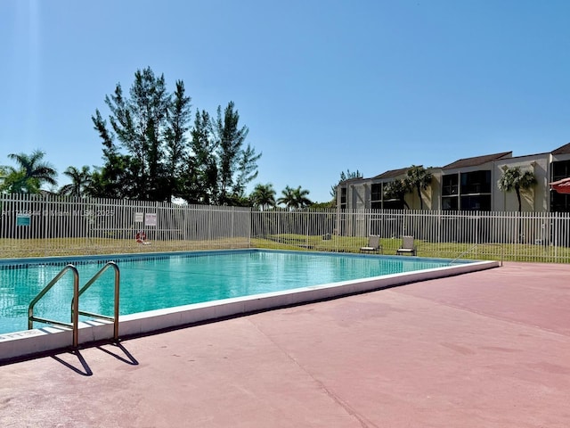 pool with a patio and fence