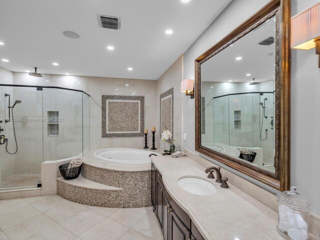 bathroom featuring plus walk in shower, vanity, and tile patterned floors