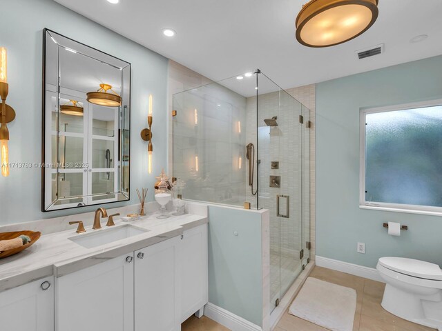 bathroom featuring tile patterned floors, toilet, vanity, and walk in shower