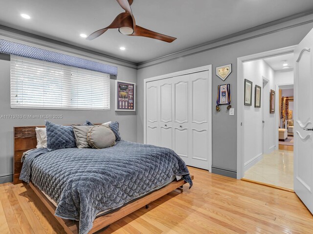 bedroom with a closet, ceiling fan, crown molding, and hardwood / wood-style flooring