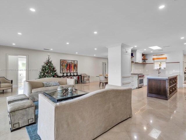 living room featuring ornamental molding and sink