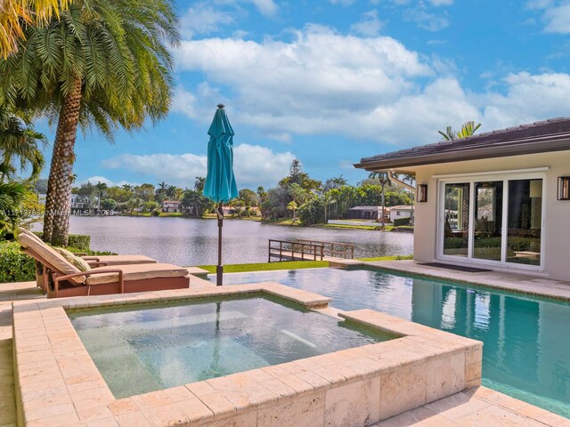 view of swimming pool with an in ground hot tub and a water view