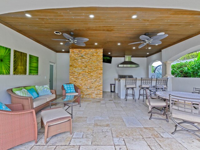 view of patio with an outdoor living space, a bar, and ceiling fan