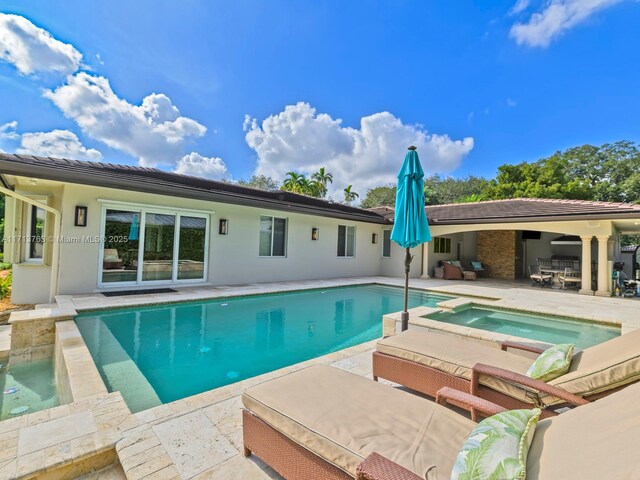 view of pool with a patio area and an in ground hot tub