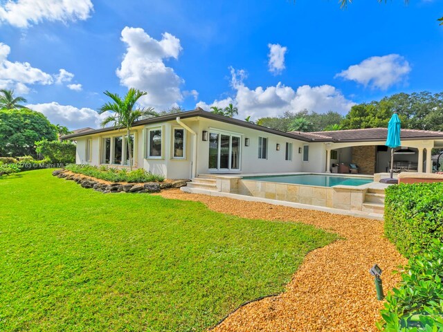 rear view of property with a patio and a lawn