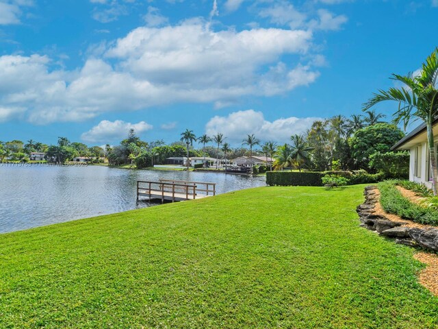 view of yard featuring a water view and a dock