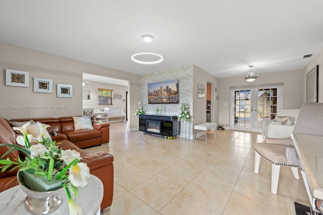 tiled living room with a fireplace and french doors