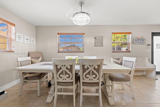 dining area featuring light tile patterned flooring and an inviting chandelier