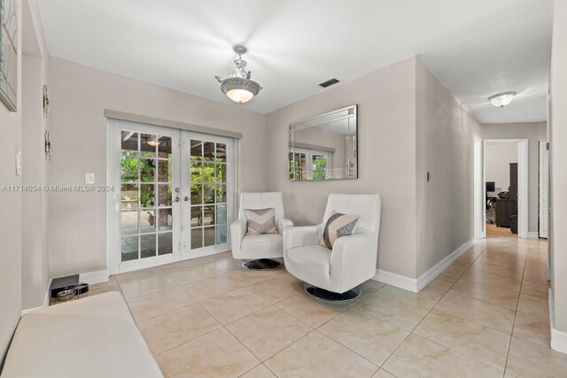 sitting room with light tile patterned floors and french doors