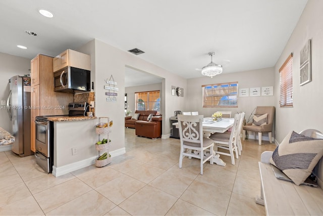 dining area featuring light tile patterned floors and a notable chandelier