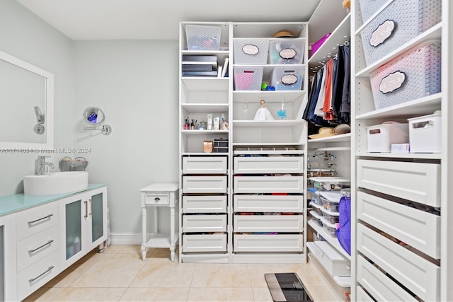 walk in closet with light tile patterned flooring and sink