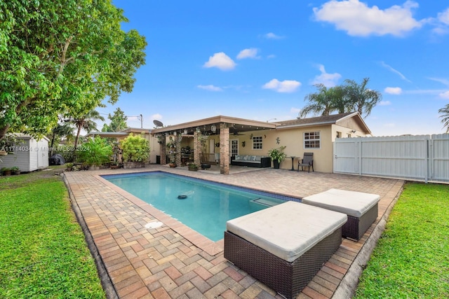 view of pool with a lawn, a patio area, and ceiling fan