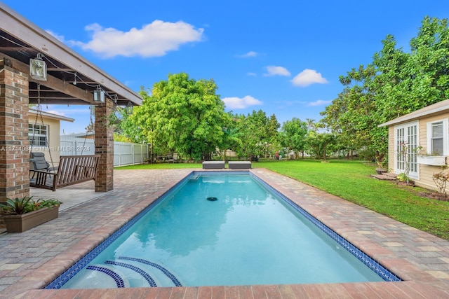 view of pool featuring a patio area, a yard, and french doors