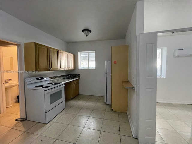 kitchen featuring light tile patterned floors, white appliances, and a wall unit AC