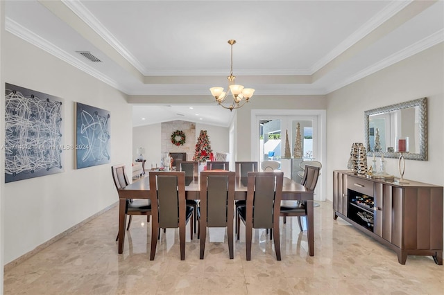 dining space featuring visible vents, an inviting chandelier, ornamental molding, vaulted ceiling, and baseboards