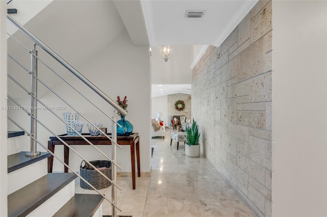 interior space featuring a large fireplace, stairway, visible vents, and an inviting chandelier