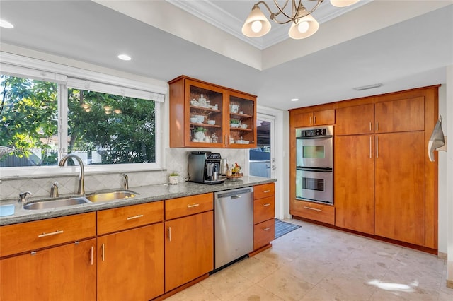 kitchen with crown molding, stainless steel appliances, tasteful backsplash, a raised ceiling, and a sink