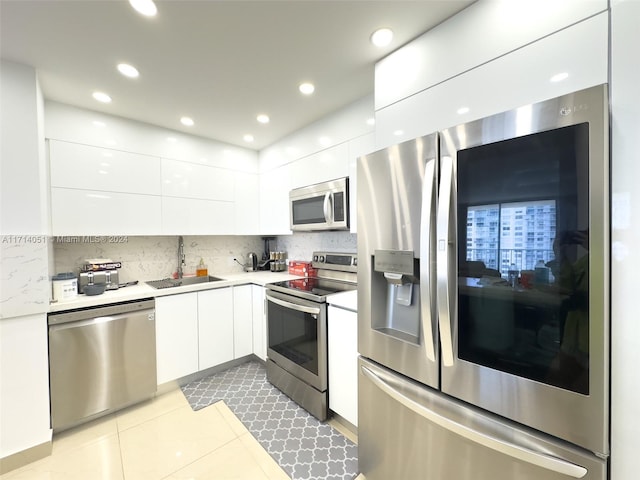 kitchen with white cabinetry, sink, light tile patterned floors, and appliances with stainless steel finishes