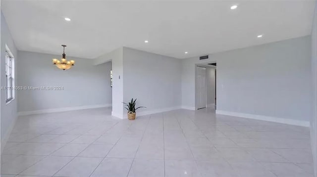 spare room featuring a notable chandelier