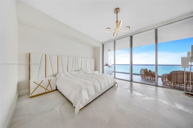 bedroom with access to exterior, a water view, a wall of windows, a notable chandelier, and concrete floors