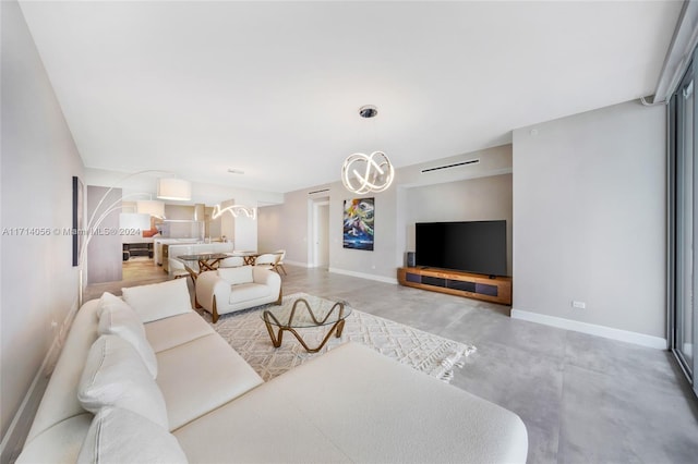 living room with concrete flooring and an inviting chandelier