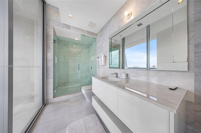 bathroom featuring vanity, toilet, walk in shower, and tile walls